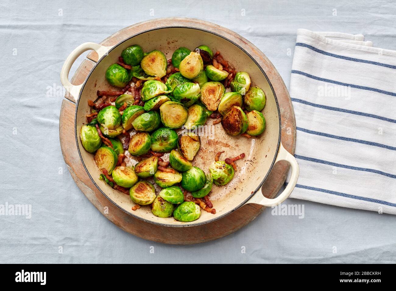 cooked Brussel sprouts bacon pan overhead browned kitchen tea towel Christmas lunch traditional seasonal Stock Photo