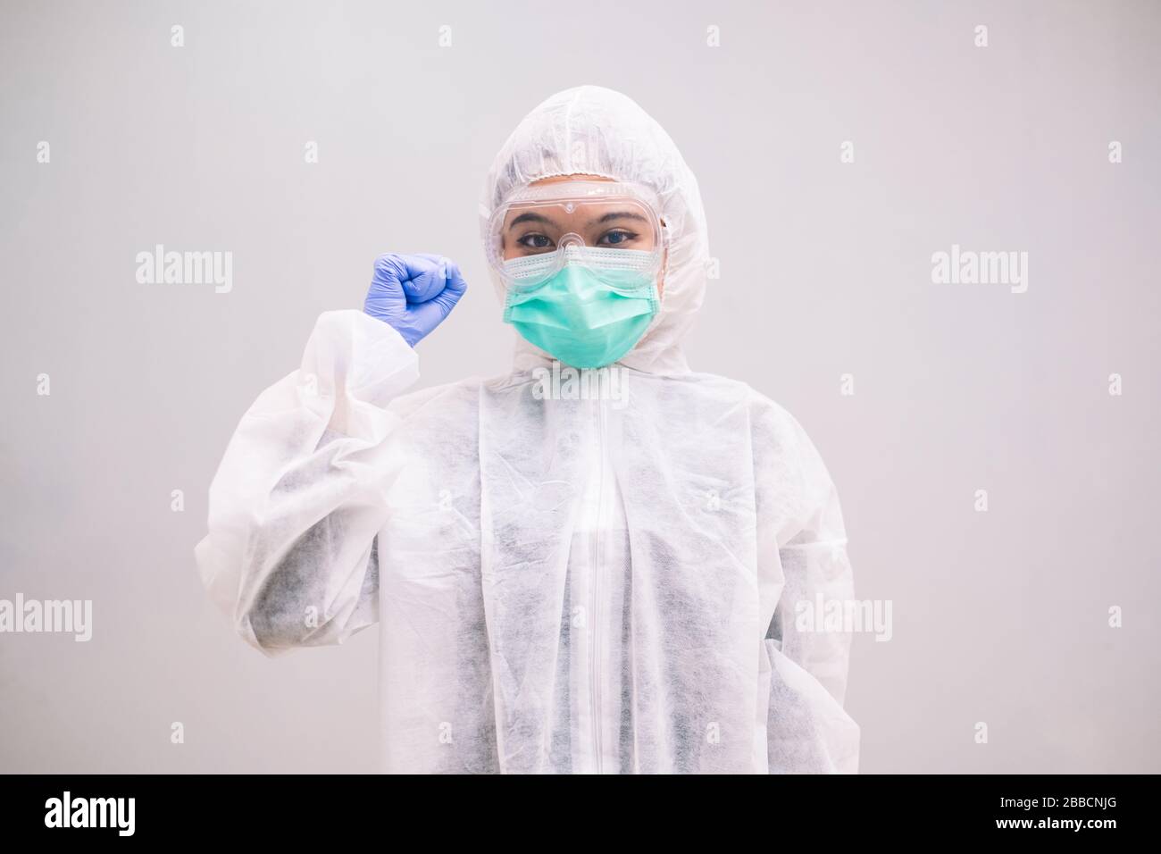 Cheerful Nurse wearing disposable coverall with mask and safety google ...