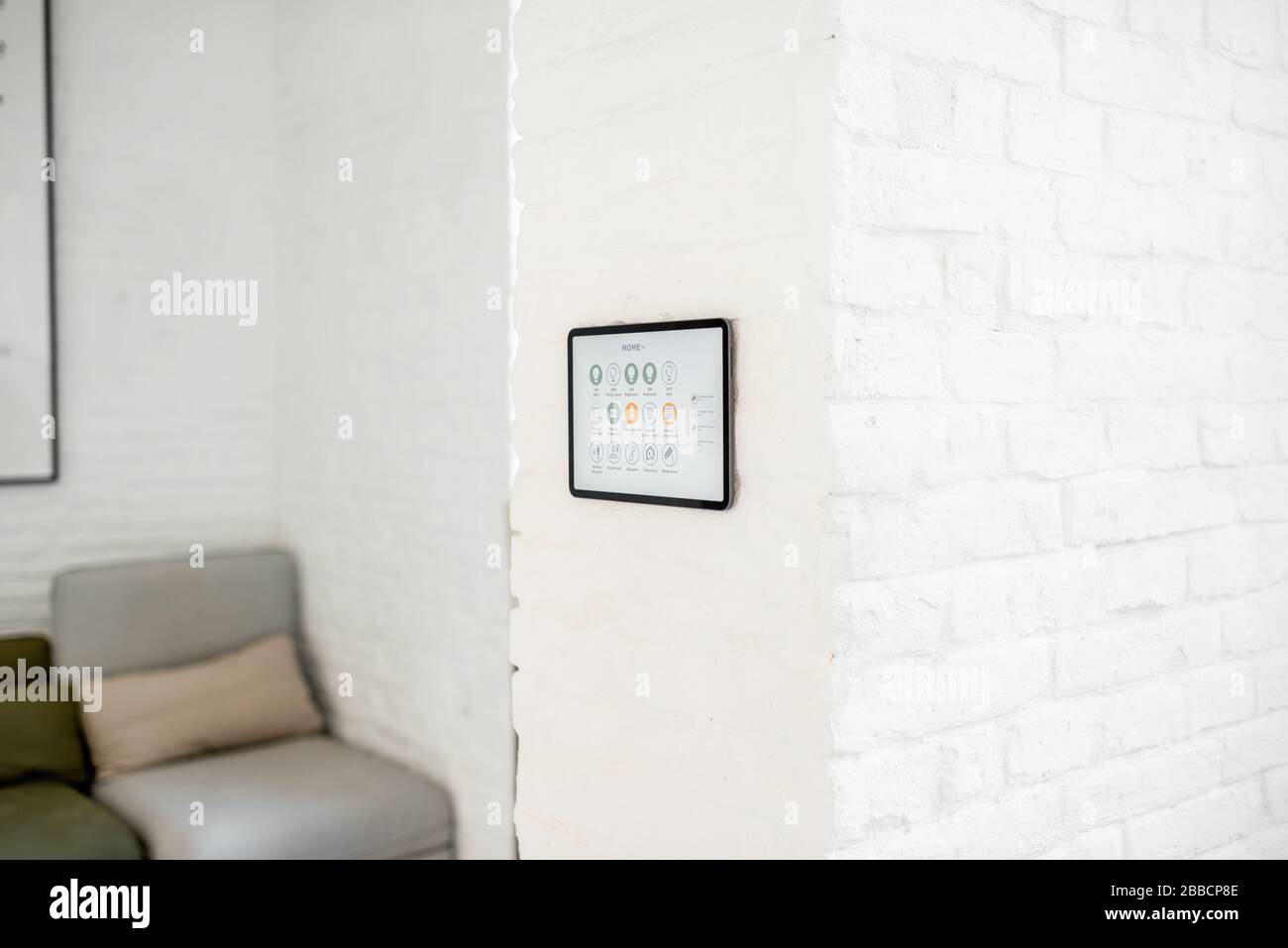 Touch screen panel with launched smart home software installed on the wall in the living room Stock Photo