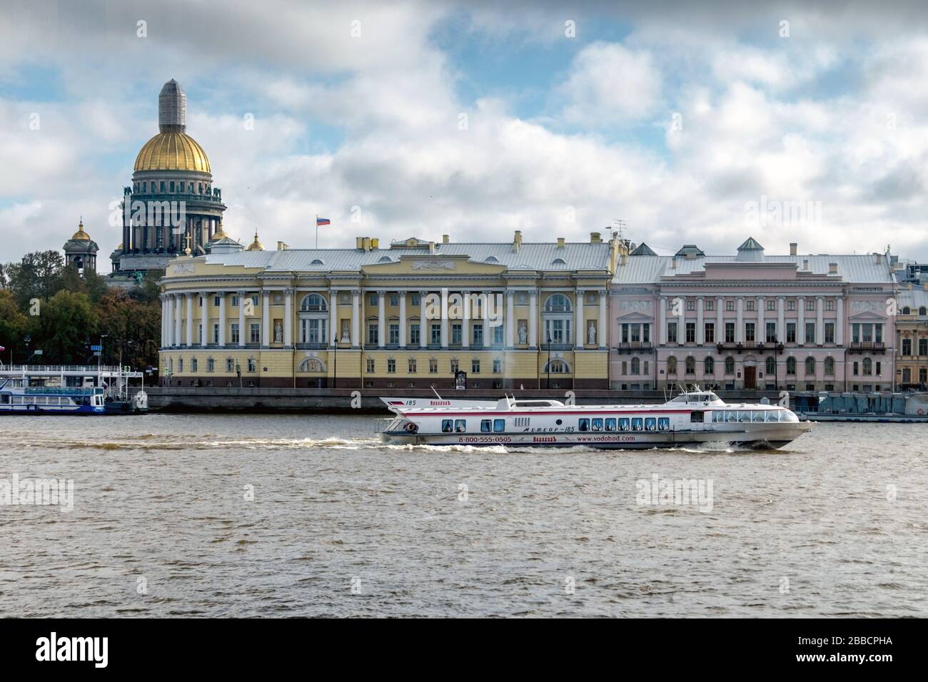 Sightseeing boat on the Neva river in view of the English embankment and St. Isaac's Cathedral, St. Petersburg, Russia Stock Photo