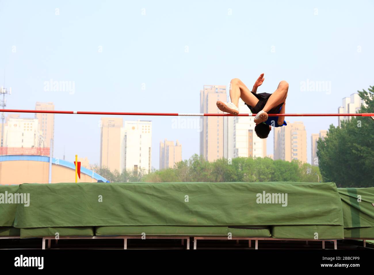 A male athlete is on the high jump Stock Photo - Alamy