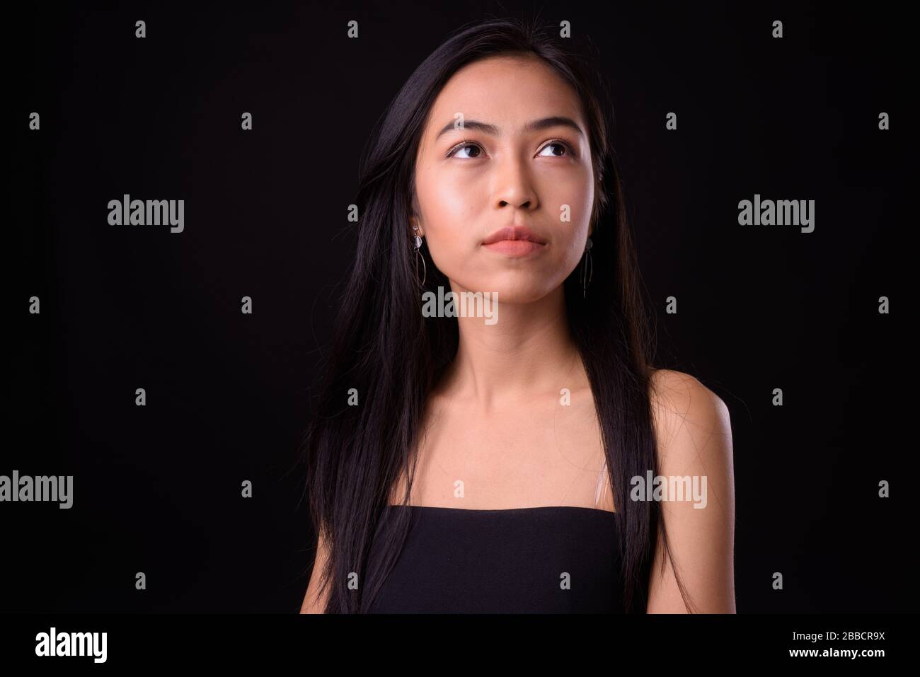 Face of young beautiful Asian woman thinking and looking up Stock Photo ...