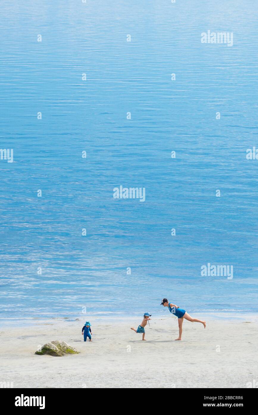 A young mother and her two kids attempt some yoga moves on Savary Island, British Columbia Stock Photo
