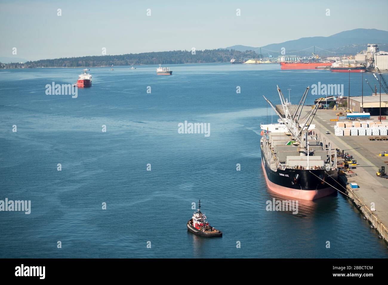Bulk cargo freighter and tugboats in North Vancouver, British Columbia, Canada Stock Photo