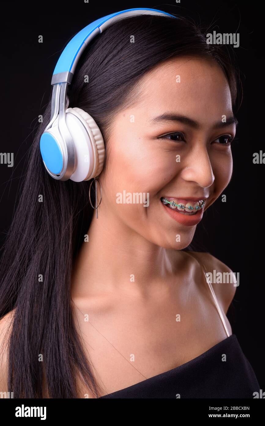 Face of happy young beautiful Asian woman listening to music Stock ...