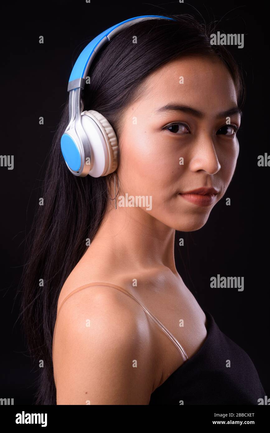 Face of young beautiful Asian woman listening to music Stock Photo - Alamy