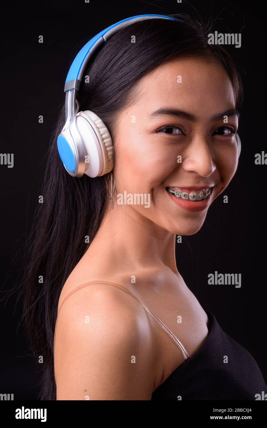 Face of happy young beautiful Asian woman listening to music Stock ...
