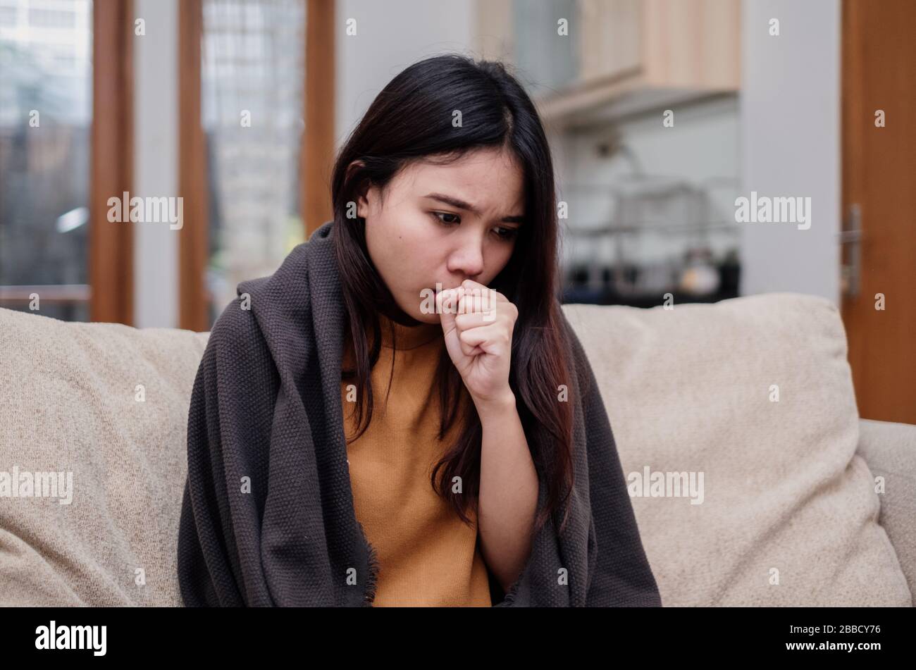 Portrait of a coughing and sick flu young woman asian at home. Pandemic 2019 Coronavirus 2019-nCoV Concept. Stock Photo