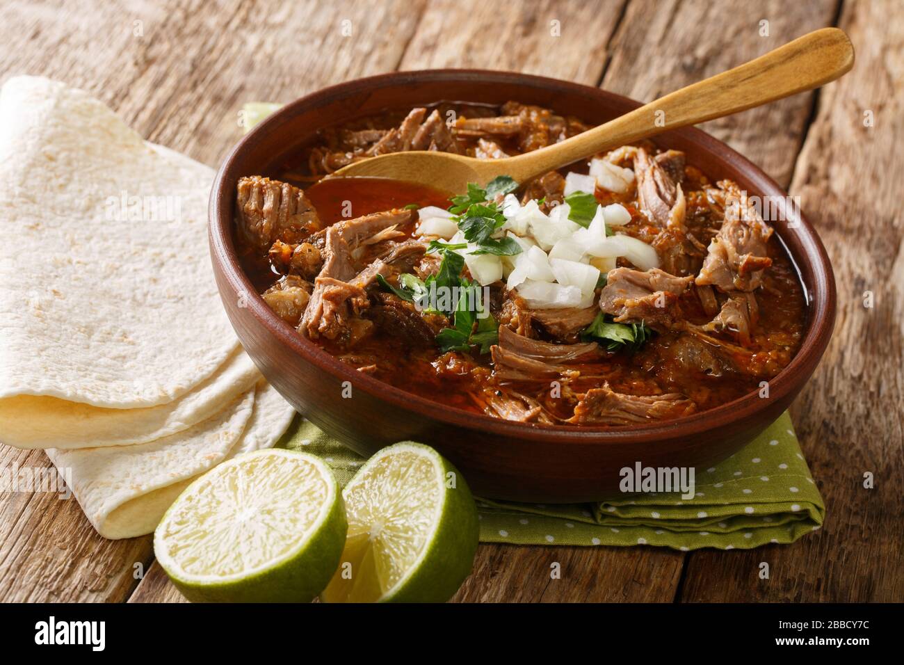 Serving of hot Birria de Res served with lime and tortilla closeup in a  bowl on the table. horizontal Stock Photo - Alamy