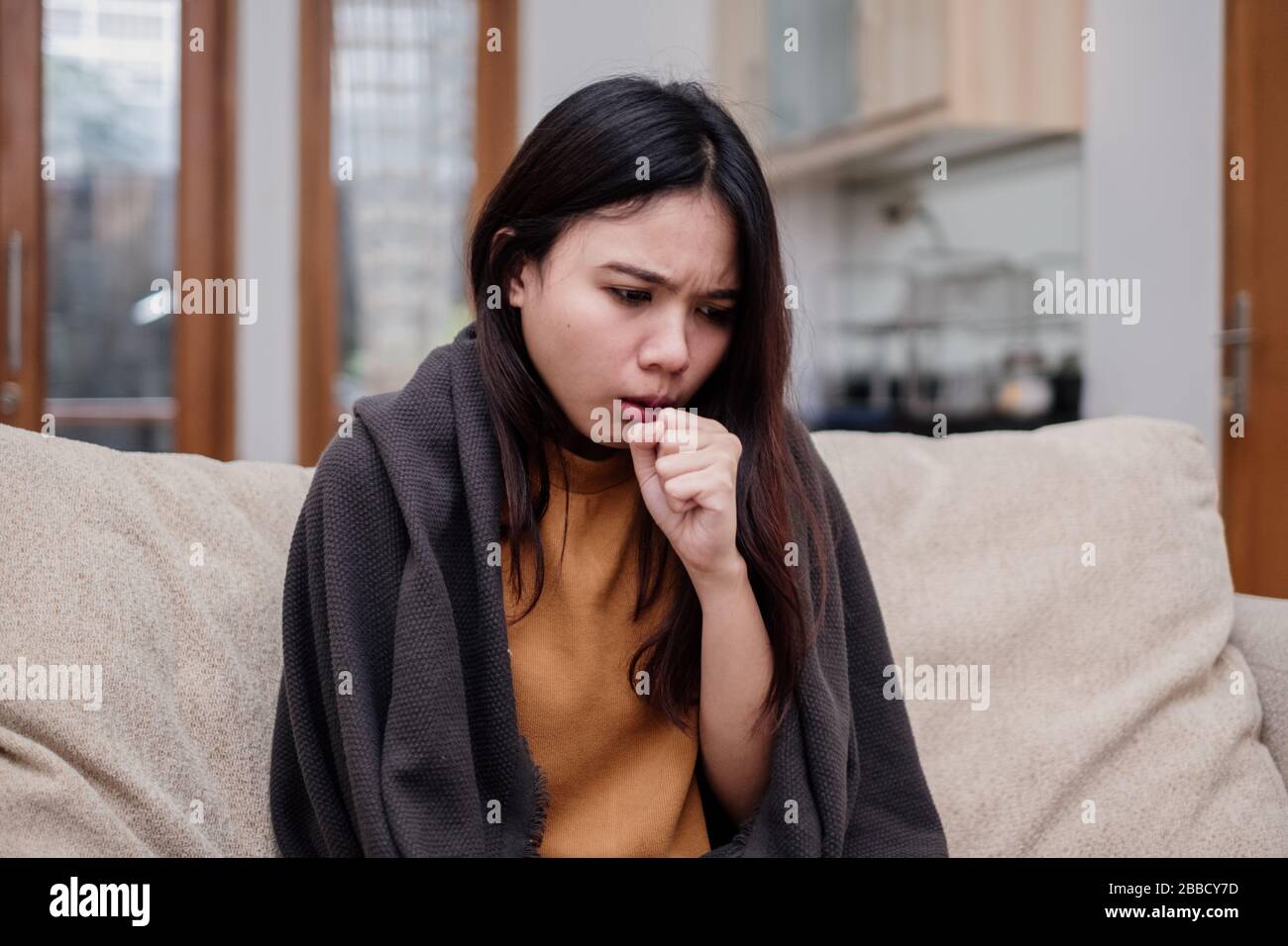 Portrait of a coughing and sick flu young woman asian at home. Pandemic 2019 Coronavirus 2019-nCoV Concept. Stock Photo