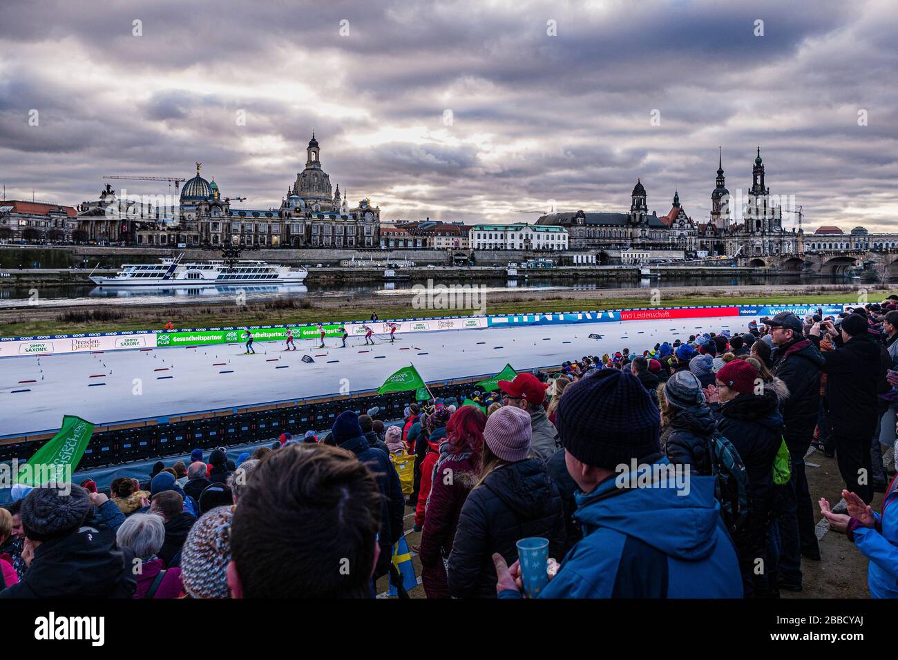 People watching the FIS cross-country skiing sprint World Cup on the banks of the river Elbe, the skyline of the baroque town in the distance Stock Photo