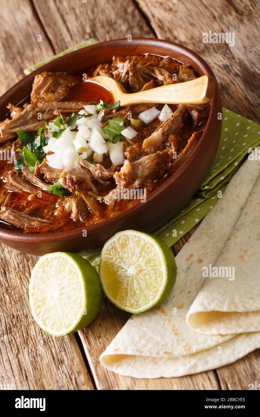 Mexican Birria de Res served with lime and tortilla closeup in a bowl on  the table. vertical Stock Photo - Alamy