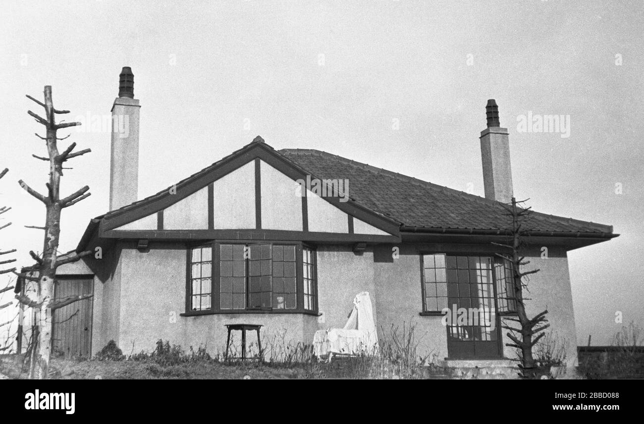 circa 1930s, a rear view of a bungalow of the era, with a cot decorated