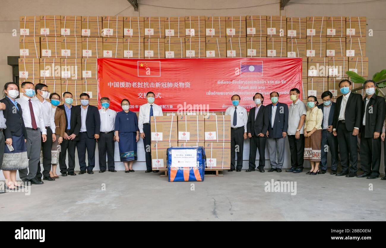 (200331) -- VIENTIANE, March 31, 2020 (Xinhua) -- Economic and commercial counselor of Chinese embassy in Laos Wang Qihui (central L) and Lao Deputy Health Minister Bounfeng Phoummalaysith (central R) pose for photos after the handover ceremony of supplies donated by China for Laos in Vientiane, Laos, March 30, 2020. Medical equipment provided by China to help Laos fight the COVID-19 pandemic were handed over in the Lao capital Vientiane on Monday. The materials include 2,016 testing kits, 5,000 sets of protective clothing and 405,000 face masks, according to the Chinese embassy in Laos. (P Stock Photo