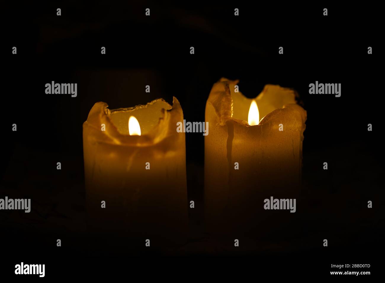 Embracing the serenity of the night, two candles flicker in the darkness, casting a gentle glow that illuminates the silent beauty of the moment. Stock Photo