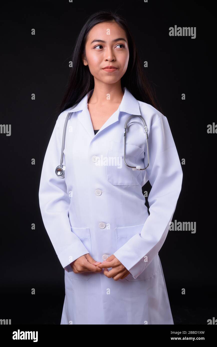 Portrait of young beautiful Asian woman doctor thinking Stock Photo - Alamy