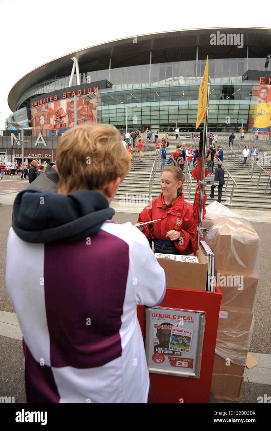 Fans purchase match day programmes outside the Emirates stadium before ...