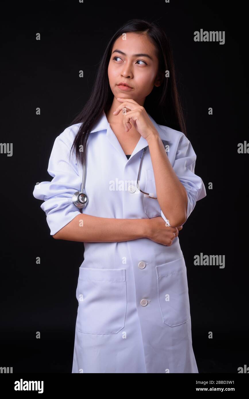 Portrait of young beautiful Asian woman doctor thinking Stock Photo - Alamy