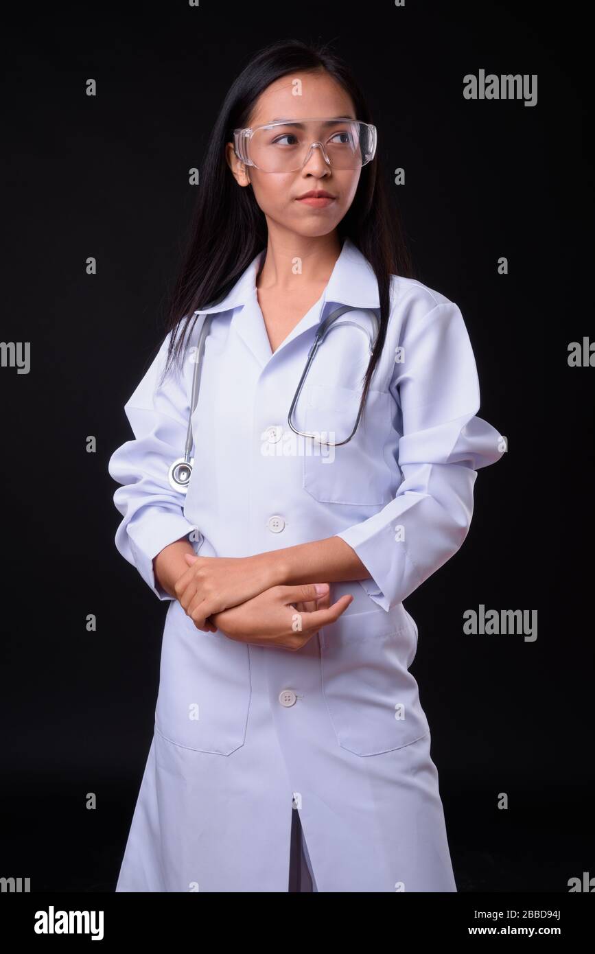 Portrait of young beautiful Asian woman doctor as scientist thinking ...