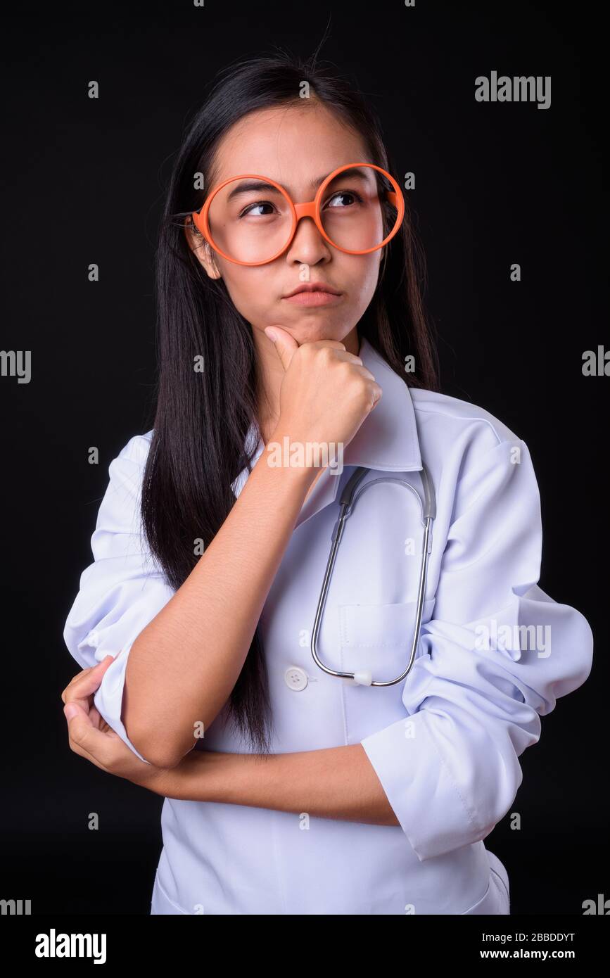 Young Asian woman doctor with eyeglasses thinking Stock Photo - Alamy