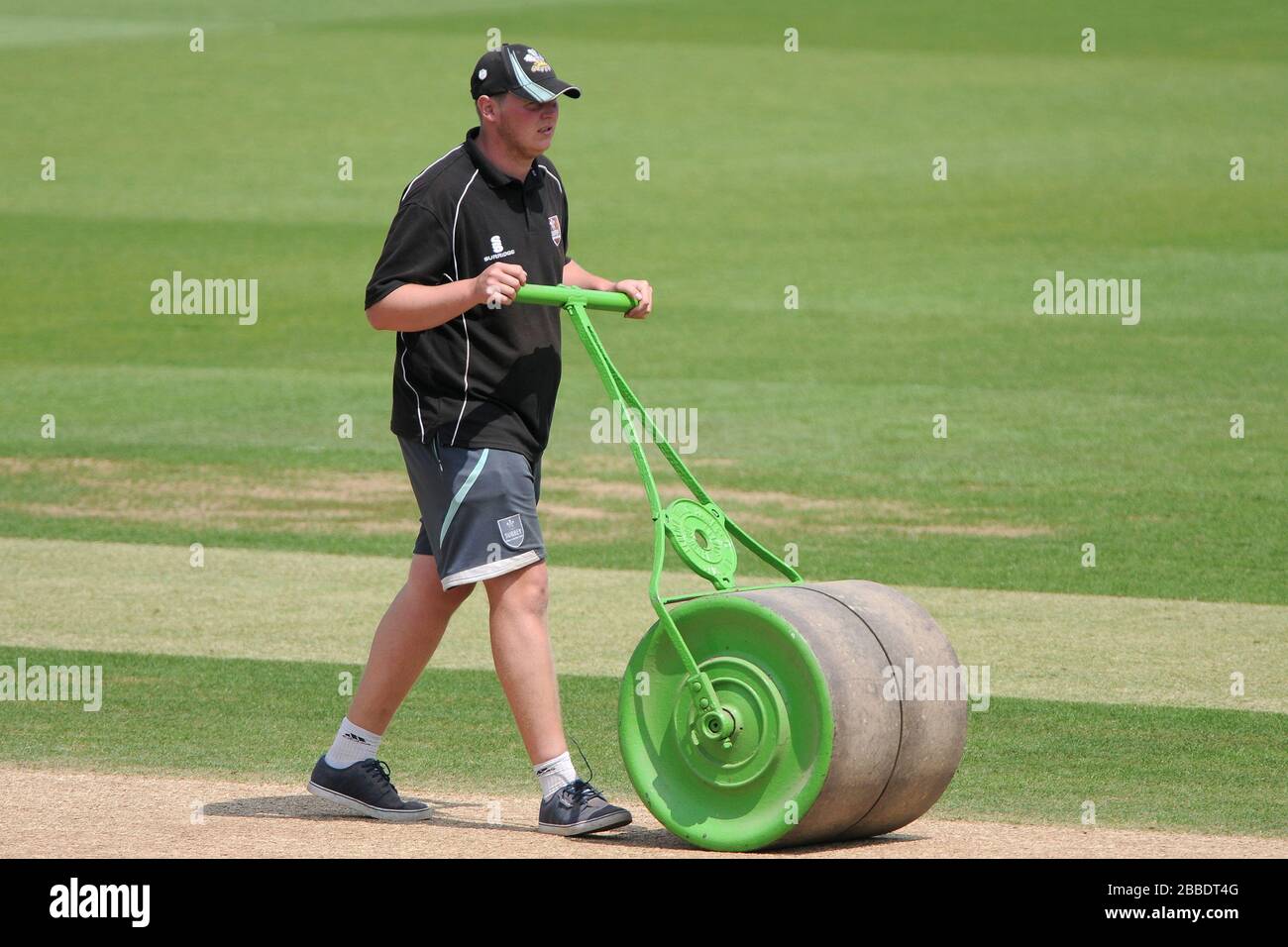 Groundstaff use a roller to tend to the wicket before the start of the days play Stock Photo