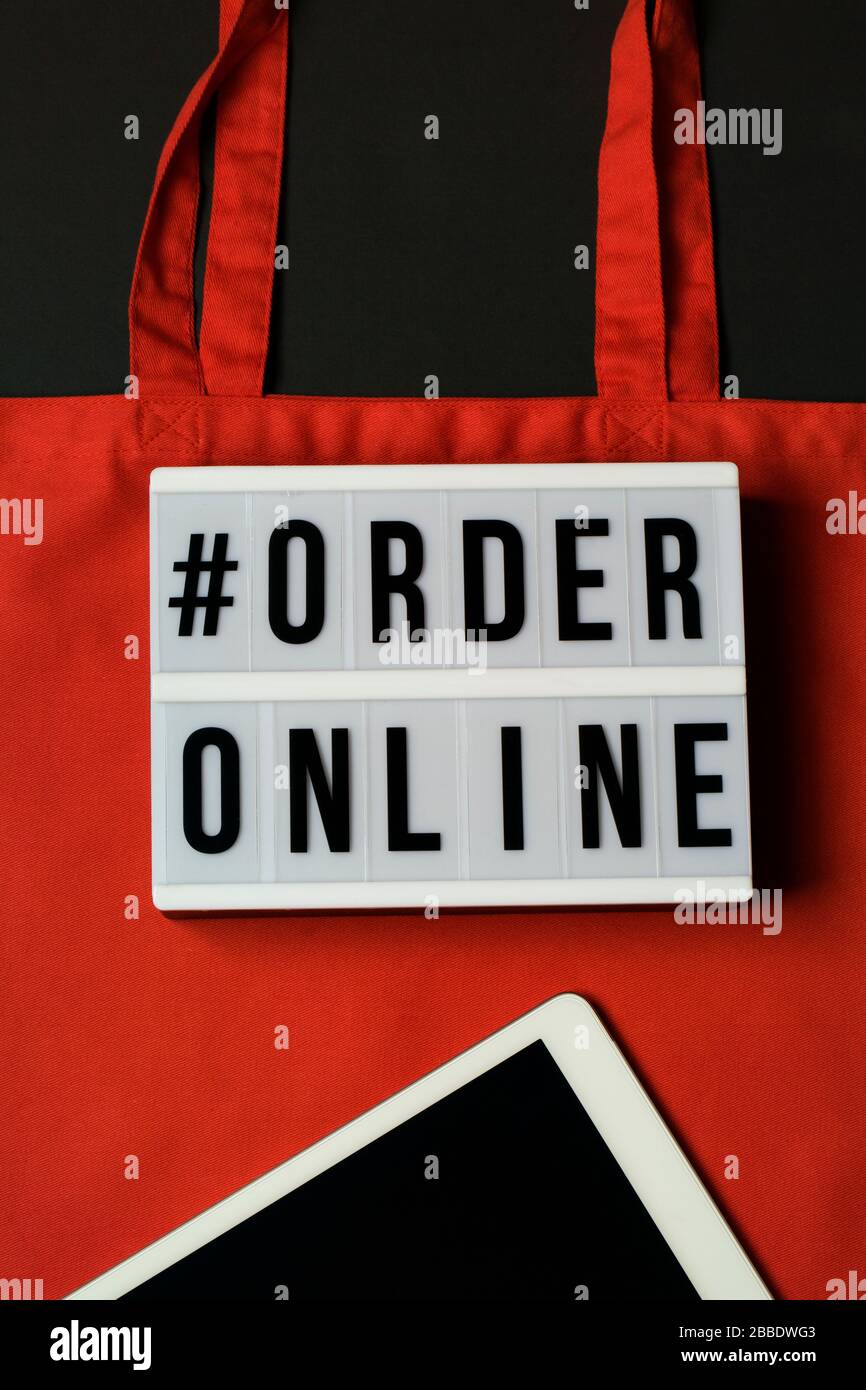 lightbox with words order online. Online shopping concept. Laptop with red cotton shopping bag