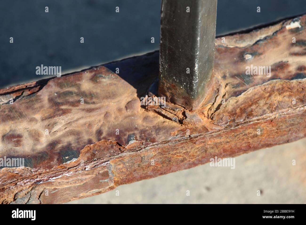A close up photograph of detail of a rusty old iron railing.  Rust damage / corrosion. Stock Photo
