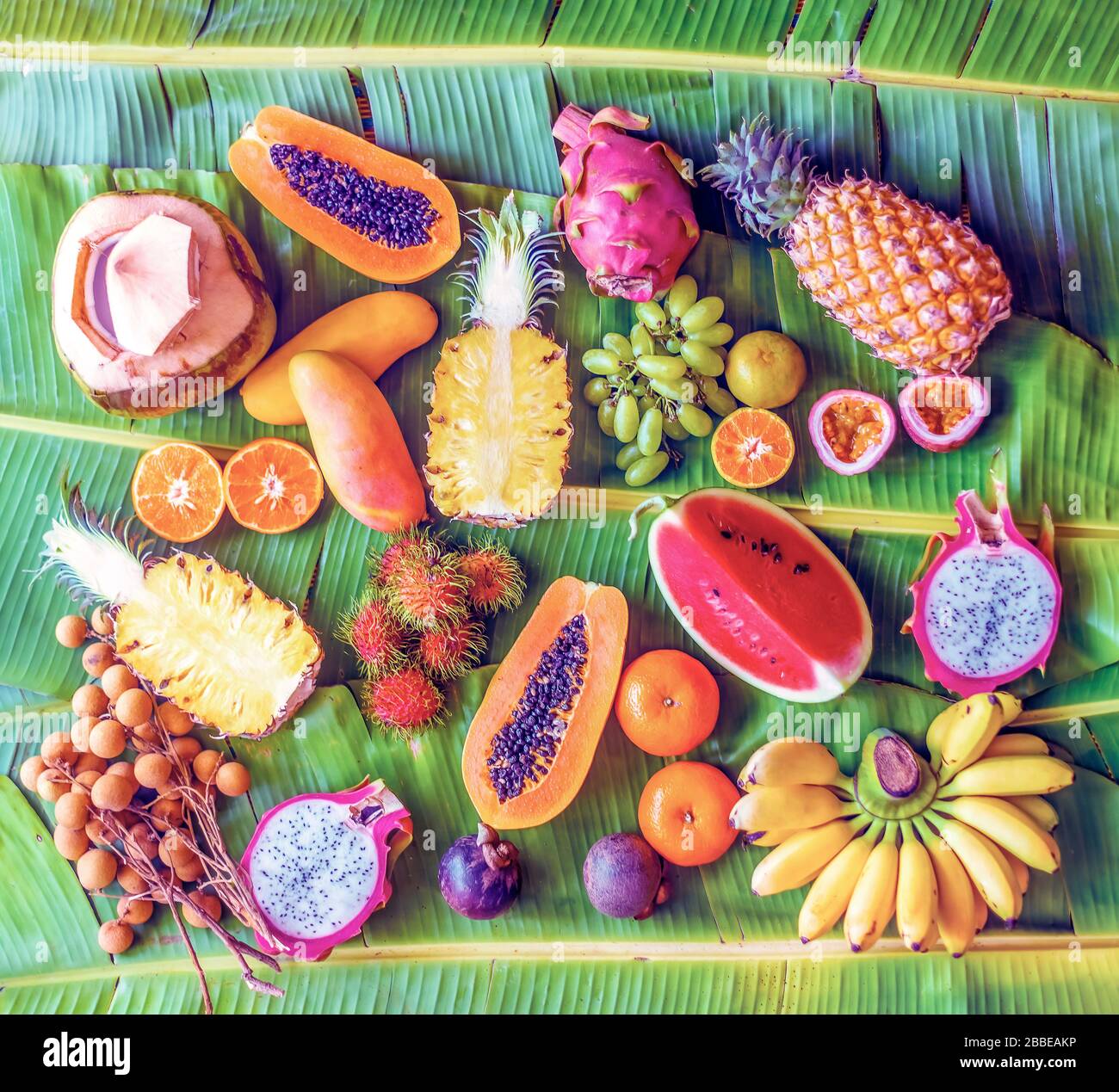 Exotic fruits on banana leaves background - papaya, mango, pineapple, banana, carambola, dragon fruit, lemon, orange, water melon, coconut, rambutan, Stock Photo