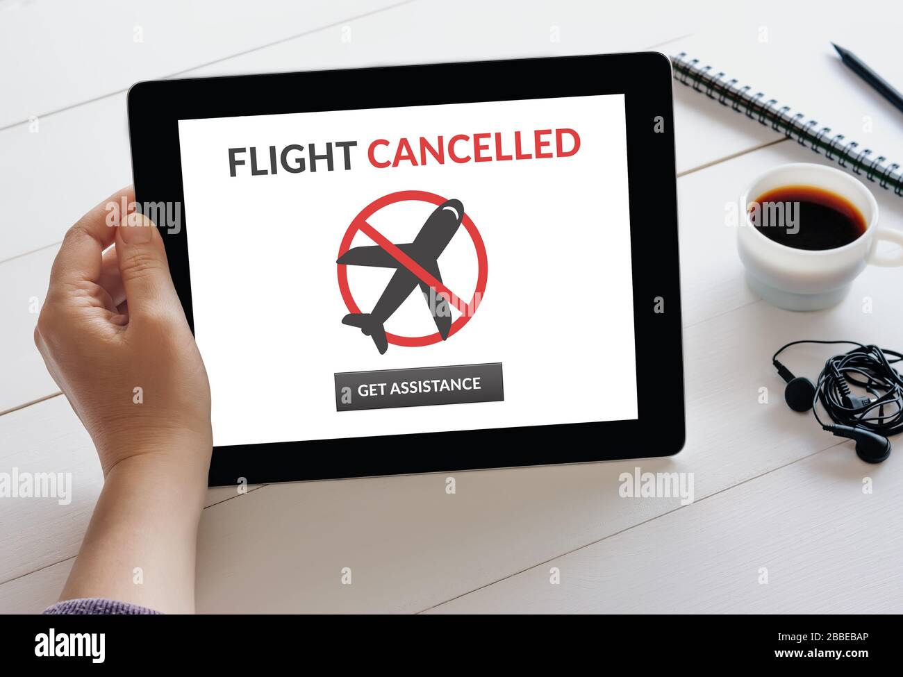 Hand holding digital tablet computer with flight cancelled concept on screen. Stock Photo