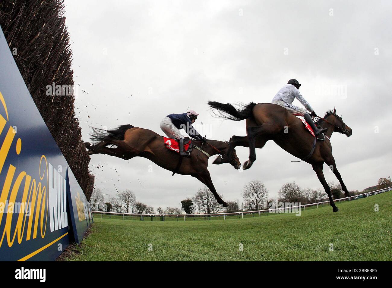 Surfing ridden by Barry Geraghty (R) and Mr Moonshine ridden by Henry Oliver in action during the Betfred Peterborough Chase at Huntingdon Racecourse, Stock Photo