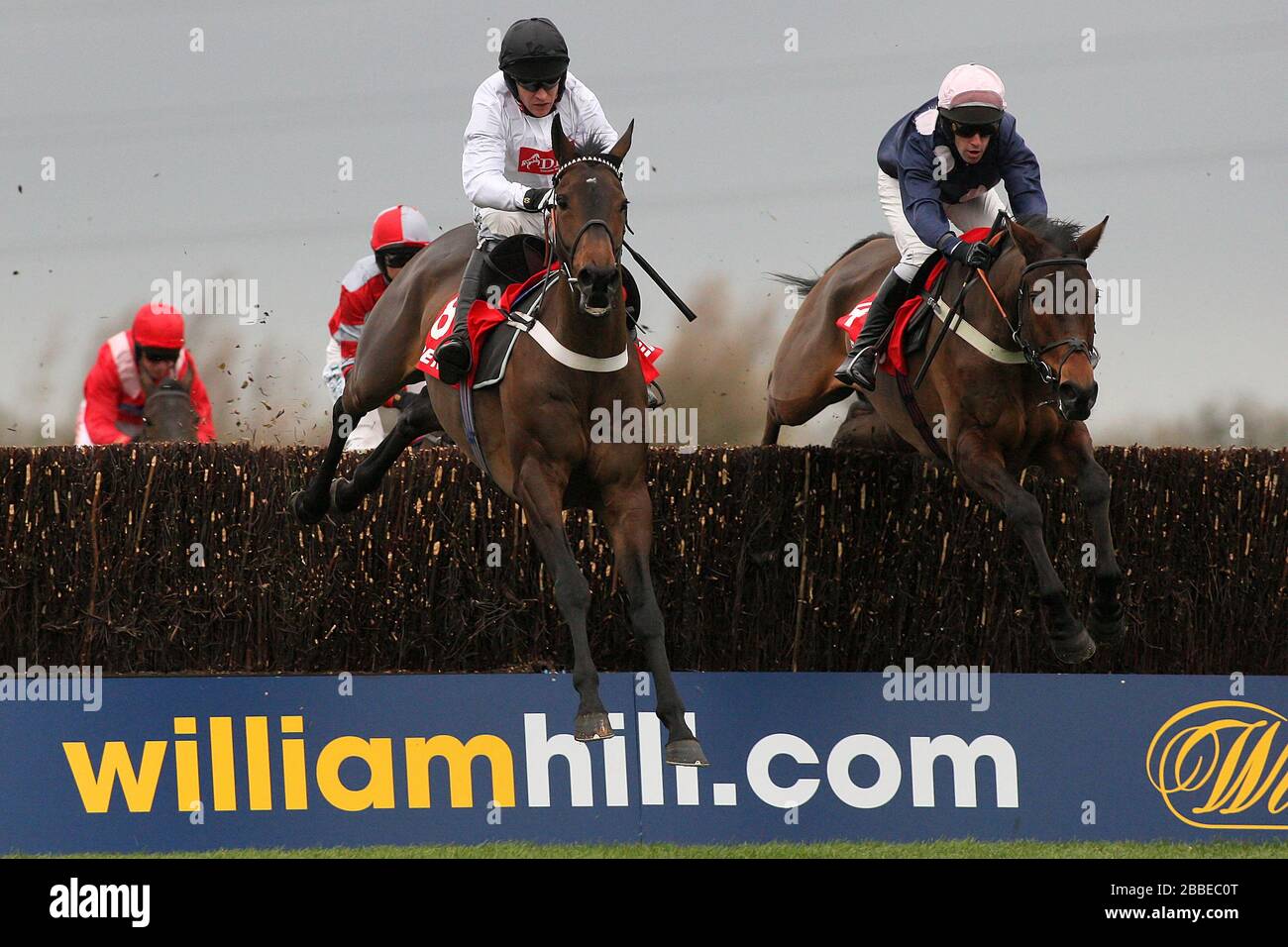Surfing ridden by Barry Geraghty (L) and Mr Moonshine ridden by Henry Oliver in action during the Betfred Peterborough Chase at Huntingdon Racecourse, Stock Photo