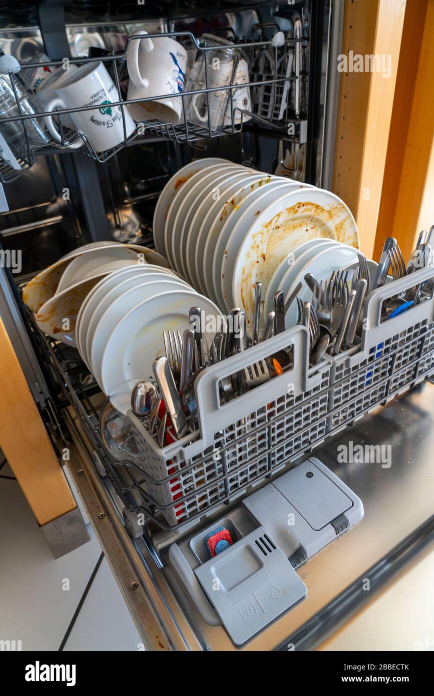 Dishwasher, full of dirty dishes, cleaning rod Stock Photo Alamy