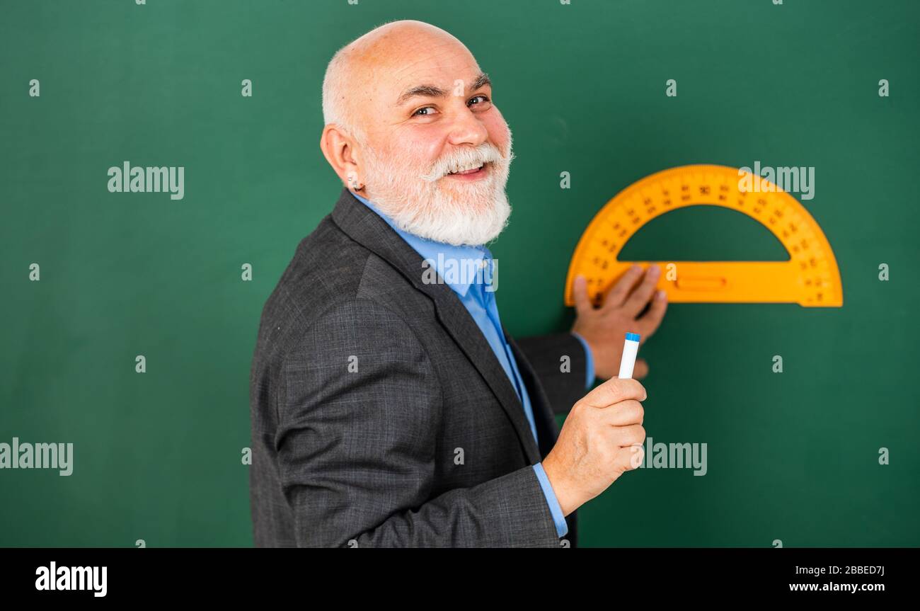 in good mood. bearded tutor man draw with ruler on blackboard. back to ...