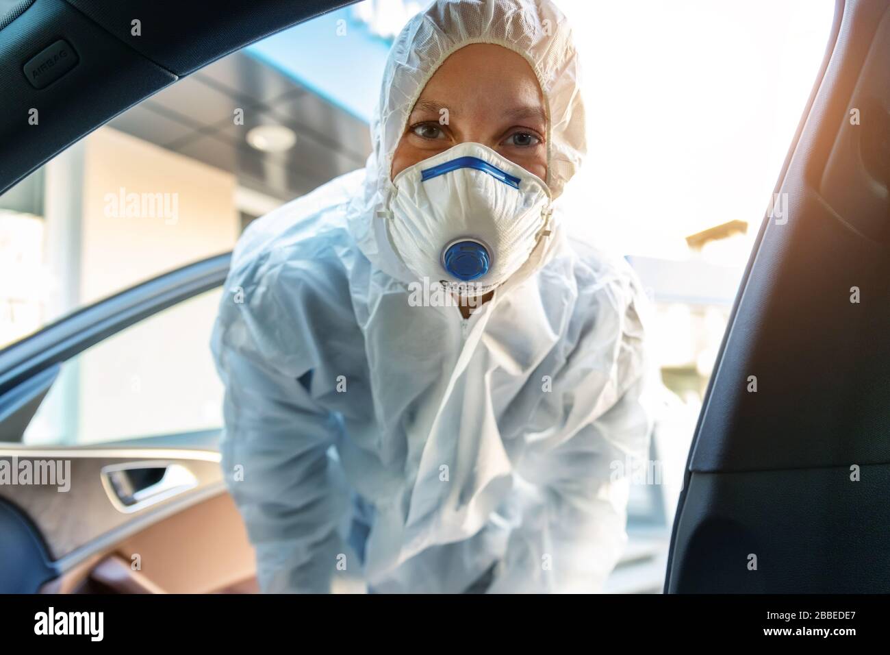 Portrait of tired exhausted female doctor, scientist or nurse wearing face  mask and biological hazmat protective suit open car door on road outdoor  Stock Photo - Alamy