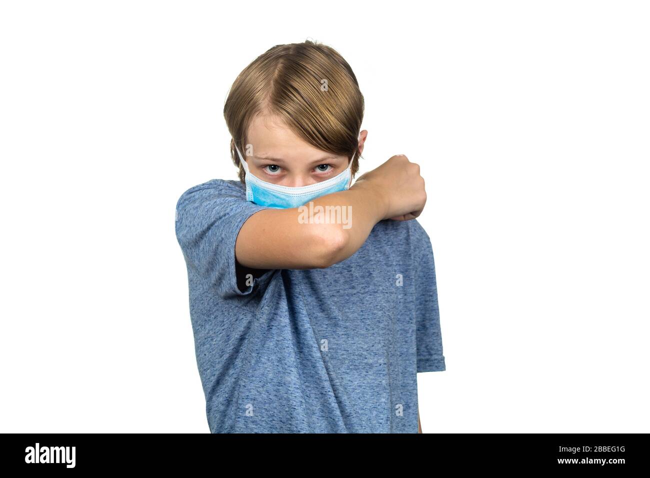 Young teenage boy wearing a protective mask coughing. Isolated on white. Stock Photo