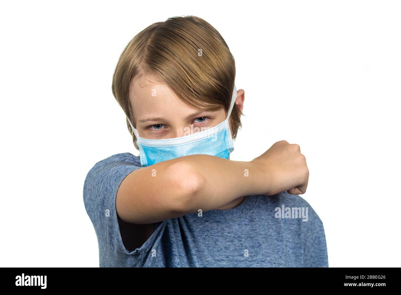 Young teenage boy wearing a protective mask coughing. Isolated on white. Stock Photo