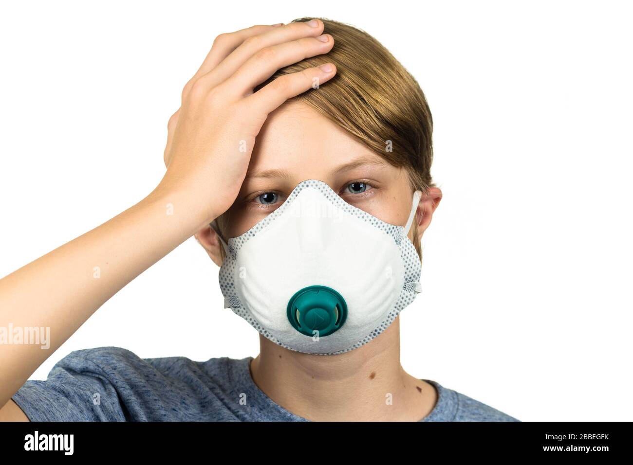 Young teenage boy with headache wearing protective mask. Isolated on white. Stock Photo