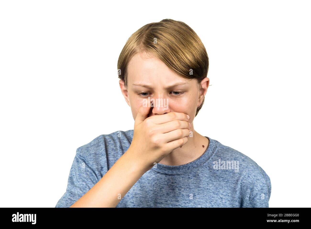 Young teenage boy coughing. Isolated on white. Stock Photo