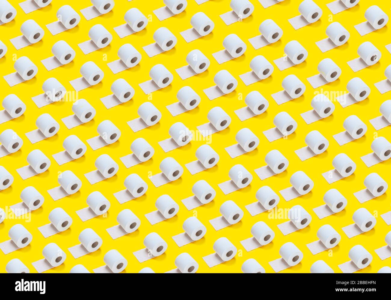 lots of toilet rolls on a yellow background Stock Photo
