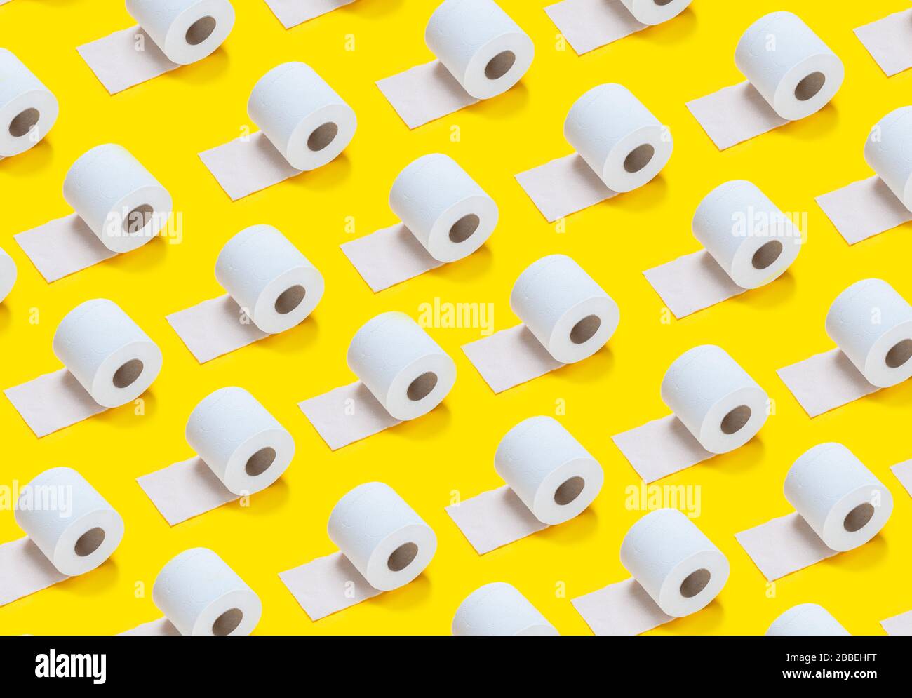 lots of toilet rolls on a yellow background Stock Photo