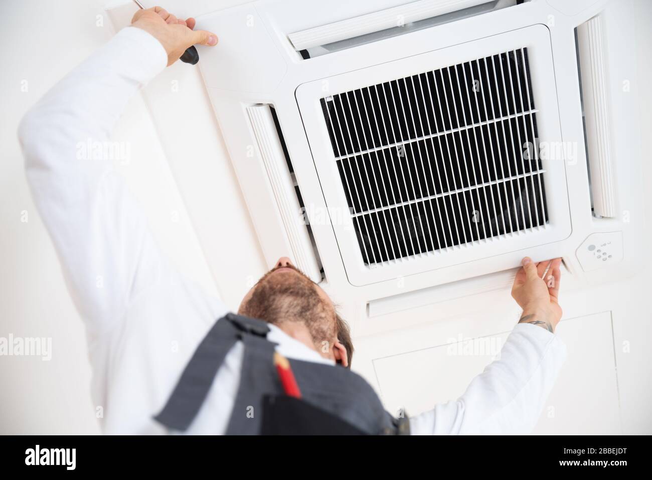 Air conditioning technician works on an air conditioner Stock Photo