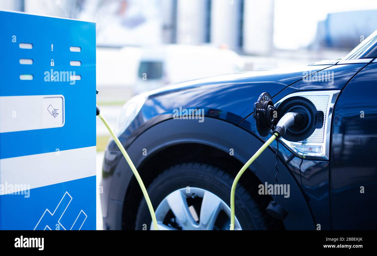 A modern car at a charging station for electric cars Stock Photo