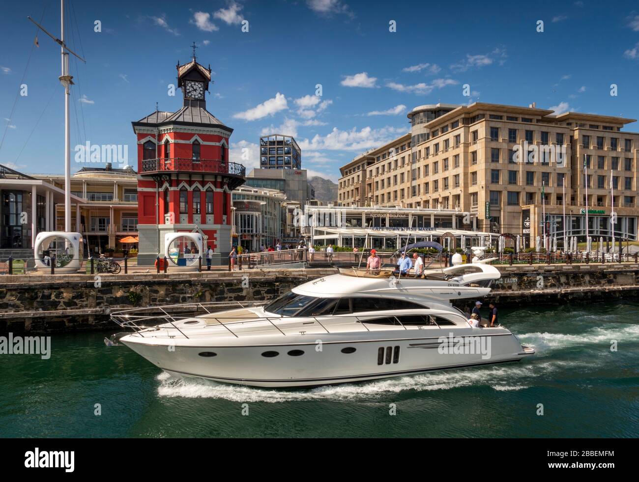 South Africa, Western Cape, Cape Town, Victoria and Alfred Waterfront, expensive motor boat passing swing bridge at historic clock tower Stock Photo