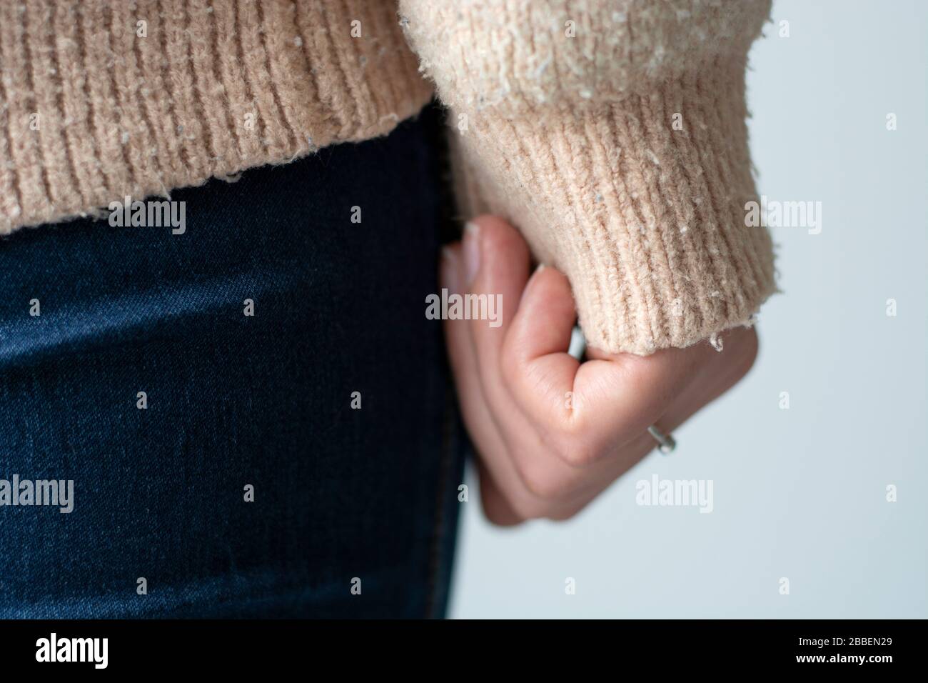 Pilled sweater. Closeup woman wearing a old used sweater with lint (pilling). Stock Photo