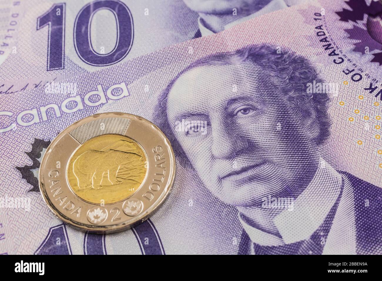 Canadian two-dollar coin on top of Canadian ten-dollar bank notes with portrait of Sir John A. Macdonald, Studio Composition, Quebec, Canada Stock Photo