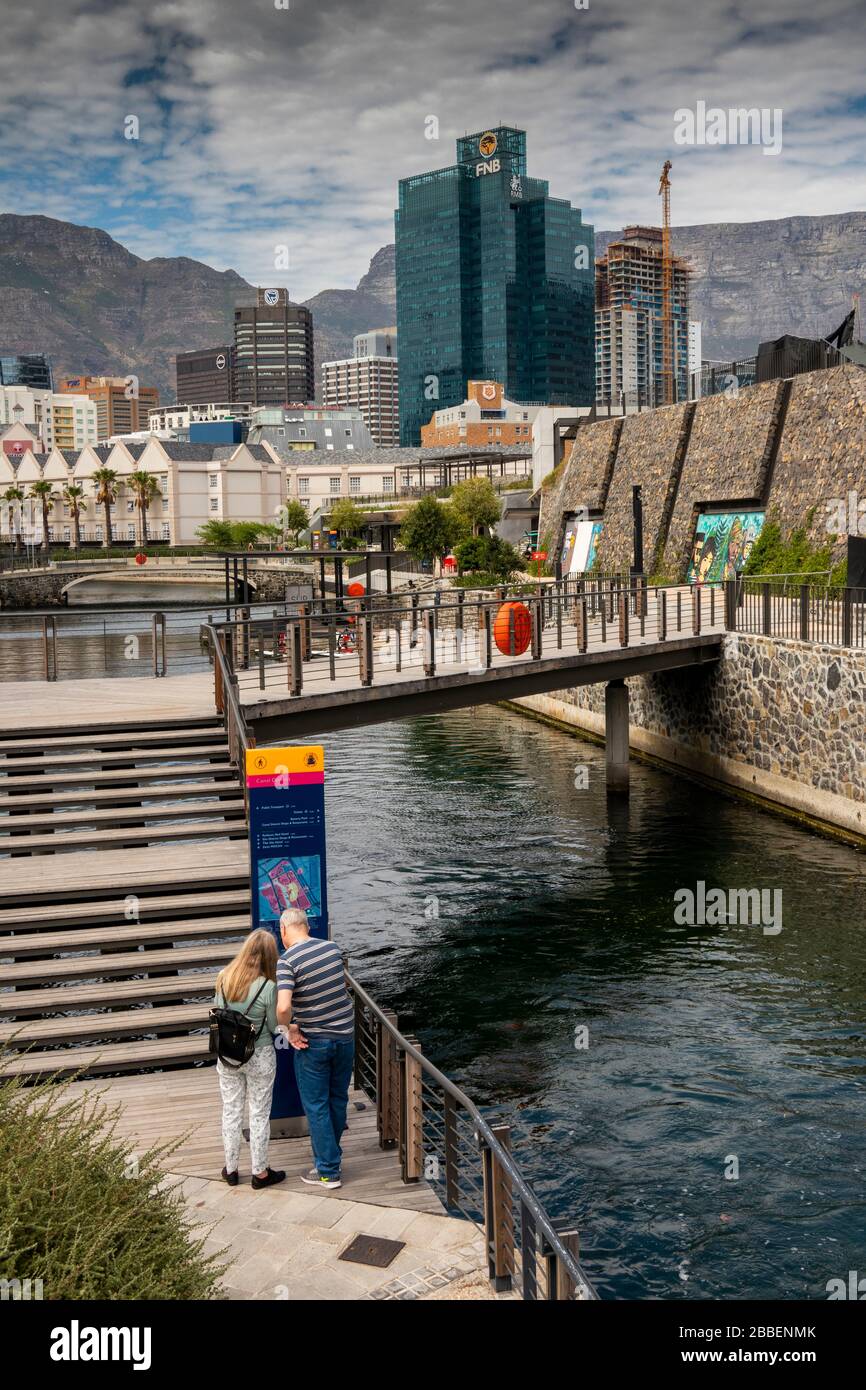 South Africa, Western Cape, Cape Town, Victoria and Alfred Waterfront, tourists walking on canal path, consulting map Stock Photo