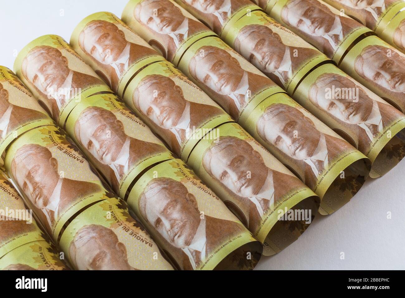 Top view of bunch of rolled up and laid flat Canadian one hundred dollar banknotes with portrait of Sir Robert L. Borden former Prime Minister of Canada, Studio Composition, Quebec, Canada Stock Photo