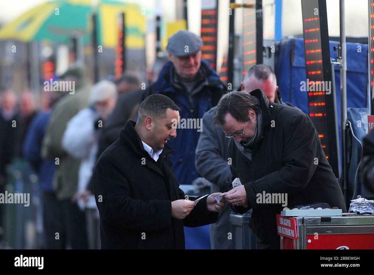 A Punter L And Bookmaker Check A Betting Slip Stock Photo Alamy