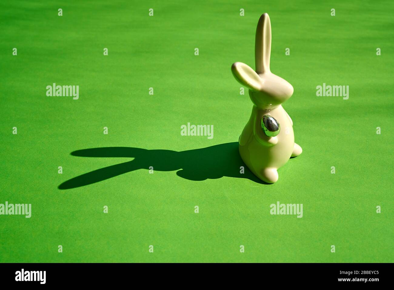 white easter bunny on green paper background Stock Photo