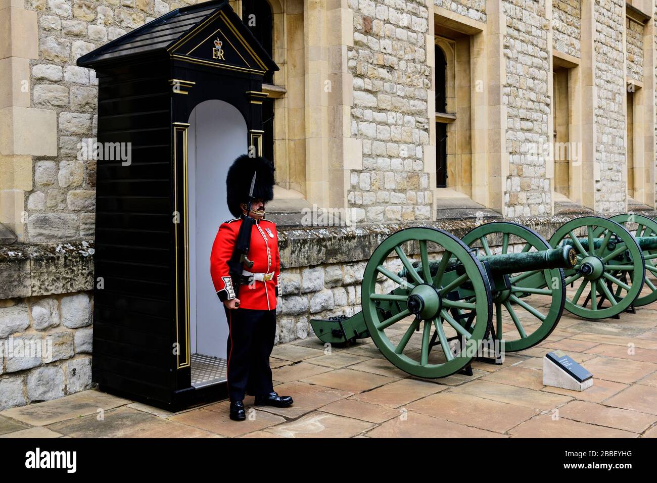A Royal Guard and a small cannon inside the Tower of London in London, England Stock Photo